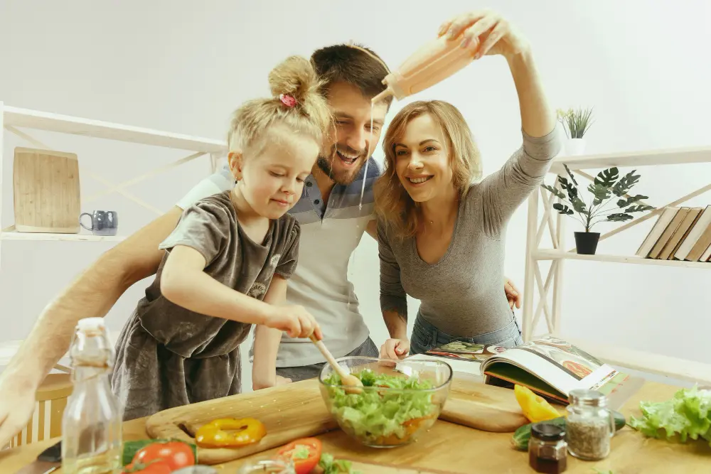 familia feliz aplicando as a orientacoes da nutricionista no cotidiano ao preparar jantar